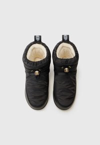 Botas de inverno acolchoadas pretas com um interior suave em creme, apresentando um botão decorativo e uma etiqueta de puxar com a marca na parte de trás.