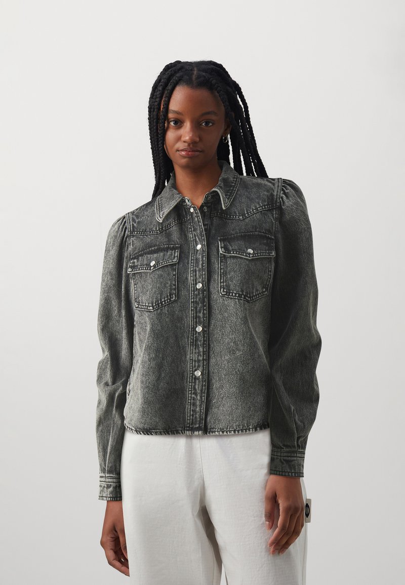 Denimhemd in vervaagd zwart met een knoopsluiting aan de voorkant, puntige kraag en twee borstzakken. Heeft pofmouwen en zichtbare stikdetails.