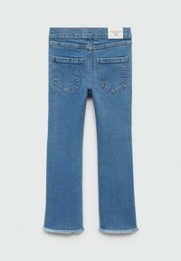 Siniset farkut, joissa on hieman levenevä muotoilu, rispaantunut helma ja kaksi takataskua. Lappu näkyvissä vyötäröllä.