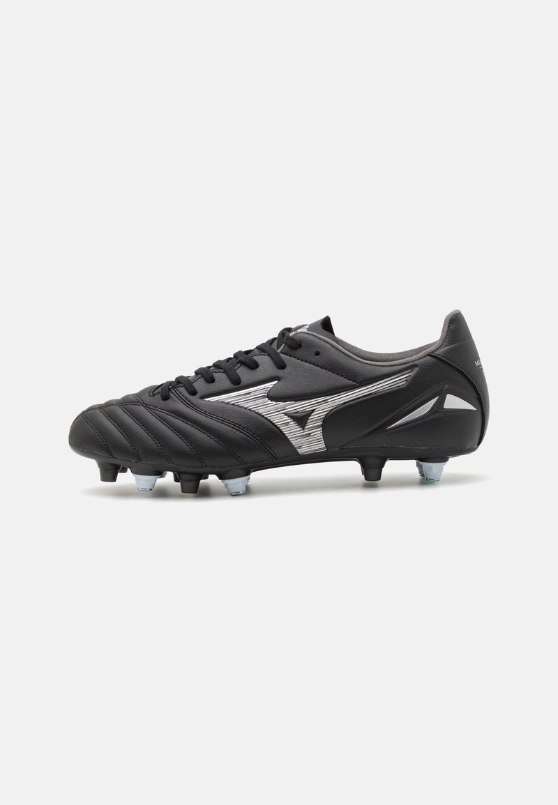 Scarpe da calcio nere con tomaia in pelle testurizzata, chiusura con lacci e dettagli argentati. Presentano tacchetti moldati per una migliore trazione su superfici erbose.