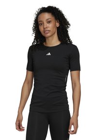 Black athletic short-sleeve shirt made of fitted material, features a round neck and a white Adidas logo on the chest.