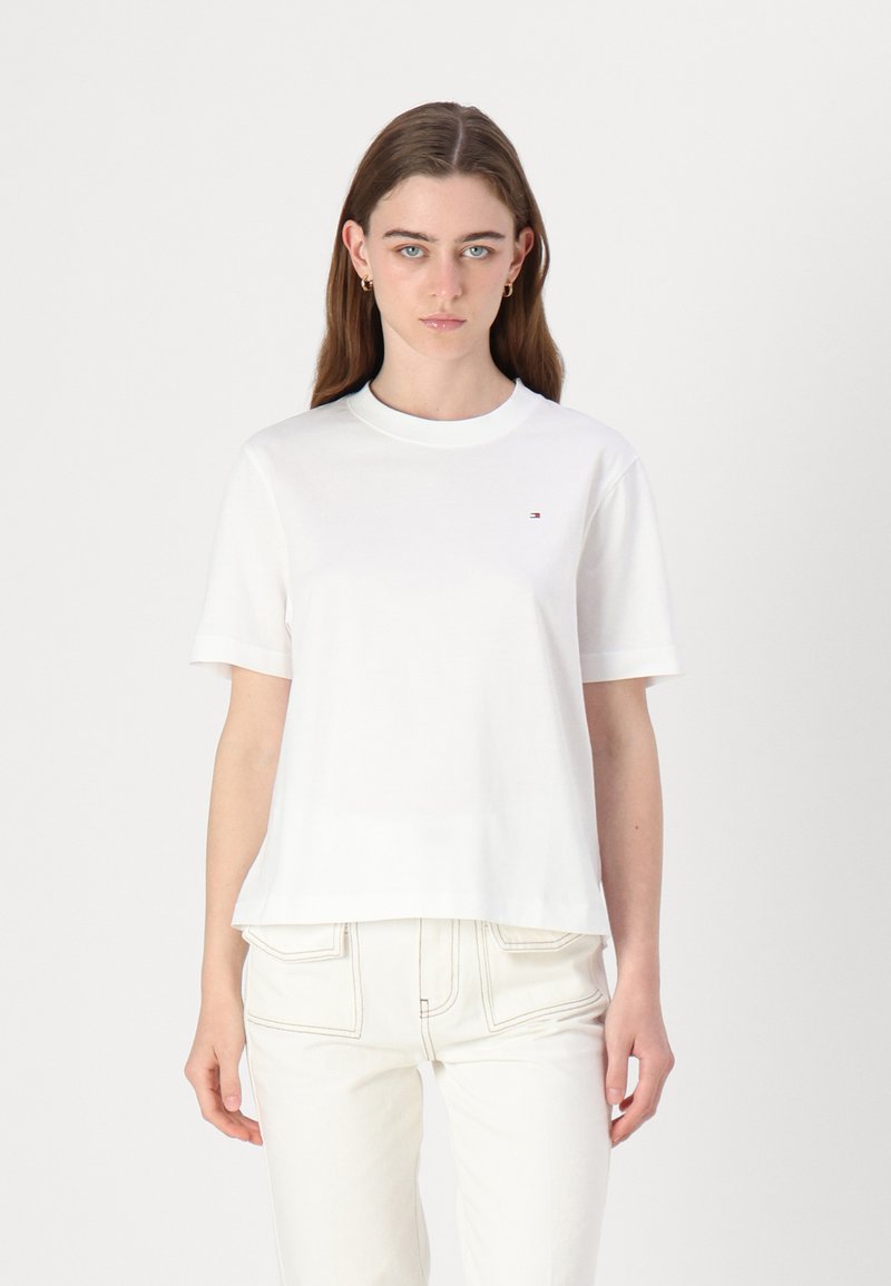 Hvid bomulds t-shirt med rund hals og korte ærmer. Har et lille logo på brystet og en afslappet pasform. Sammen med lyse bukser.