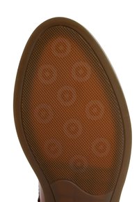Suela de zapato de goma marrón con una superficie texturizada, que presenta patrones circulares y un borde ligeramente elevado.