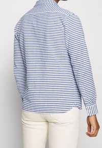 Modrá a bílá pruhovaná dlouhá košile s knoflíkovým límečkem, rovnými lemy a manžetami s knoflíky, vyrobená z lehkého materiálu.