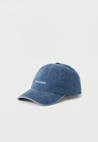 Gorra de béisbol de algodón azul con correa ajustable, visera curvada y "RAW ENERGY" bordado en blanco en la parte frontal. Textura suave.