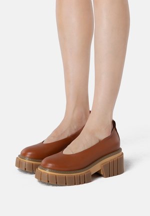 Brune læderplatformsko med rund tå, slip-on-design og kraftig rillede sål. Overdelen har en glat tekstur med få detaljer.