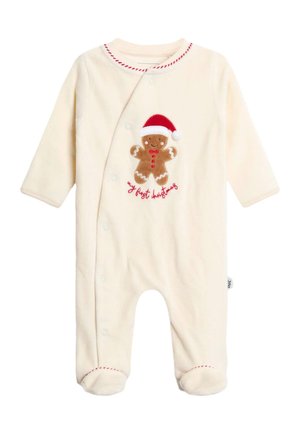 Flødefarvet babyheldragt med lange ærmer, fødder, rød syning og en peberkagemand iført en nissehue med teksten "my first Christmas".