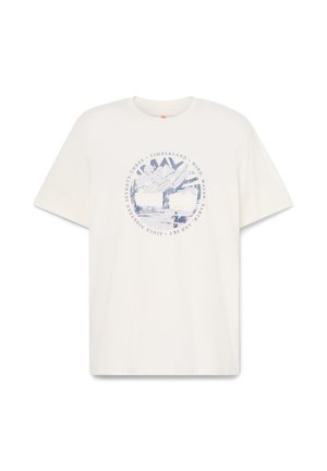 T-shirt bianca in cotone con maniche corte. Presenta una grafica di una montagna blu e un paesaggio all'interno di un design testuale circolare. Retro semplice.