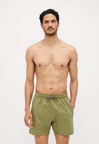 Shorts de bain vert olive en matériau léger, avec une taille élastique dotée d'un cordon de serrage et des poches latérales.