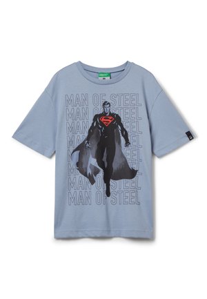 Hellblaues T-Shirt mit kurzen Ärmeln, das ein schwarzes grafisches Motiv eines Superhelden im Flug zeigt, mit rotem und schwarzem Text "MAN OF STEEL", der im Hintergrund wiederholt wird.