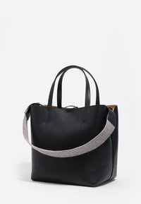 Czarna fakturowana skórzana torba na ramię z dwoma uchwytami i szerokim, szarym, plecionym paskiem na ramię na białym tle.