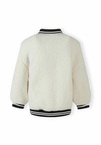 Giacca in shearling bianca con una vestibilità comoda, dotata di colletto e polsini a costine bianco e nero. Texture morbida senza chiusure visibili.