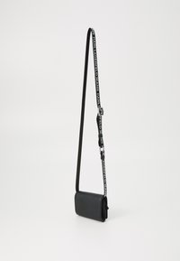 Borsa a tracolla nera realizzata in materiale testurizzato. Presenta una forma rettangolare, una tracolla regolabile con logo e dettagli in metallo argentato.