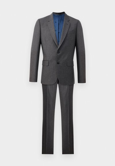 Traje gris a medida, compuesto de una tela fina. La chaqueta cuenta con solapa muesca y dos botones; los pantalones tienen un diseño de frente plano y pierna recta.