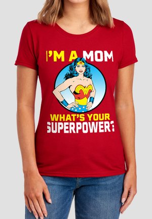 Red shirt with Wonder Woman graphic and text saying "I'm a mom, what's your superpower?" worn by person with blue jeans.