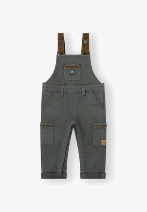Pantalones de tirantes grises para niño pequeño con tirantes ajustables marrones, un bolsillo frontal en el pecho, bolsillos laterales con ribete marrón y puños de pantalón enrollados.