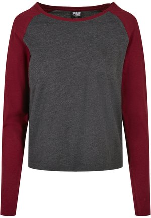 Maglietta grigia con maniche raglan color bordeaux, realizzata in un tessuto morbido; scollo a giro, vestibilità ampia e senza motivi visibili o dettagli in metallo.