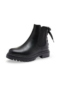 Bottine en cuir noir avec panneau latéral élastique, semelle épaisse et dos décoratif à lacets avec lien en ruban sur fond blanc.