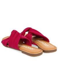 Sandalias deslizantes fucsias con parte superior de tela suave, suela plana color marrón y plantilla con marca. Presentan diseño de punta abierta y sin trasera.