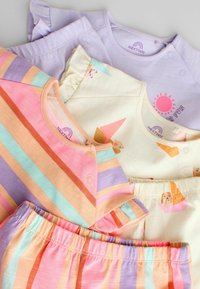 Trois ensembles colorés de vêtements pour bébés avec des manches courtes et des pantalons, présentant des rayures, des imprimés animaux et des teintes pastel.