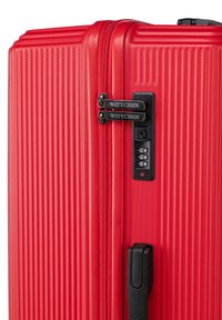 Valigia rigida rossa con scanalature testurizzate, doppie cerniere, tiranti di marca e sistema di chiusura a combinazione. Design durevole con una finitura elegante.