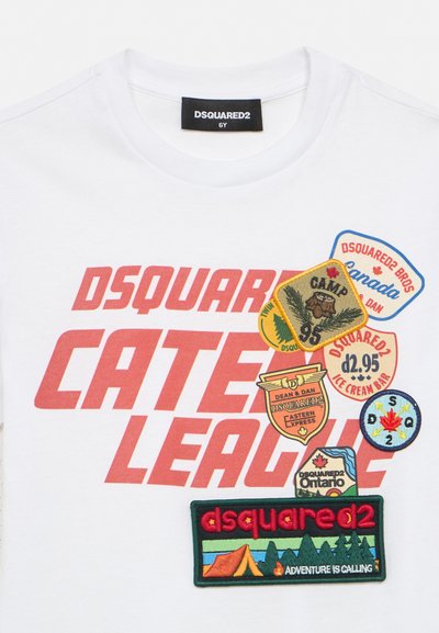 T-shirt blanc enfant avec grand texte rouge "Dsquared2 Caten League" et six patchs colorés aux thèmes camping, Canada et aventure.