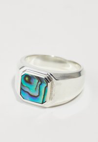 Anillo de plata con un incrustación octagonal de abulón azul-verde que presenta patrones de remolino distintivos; acabado suave y pulido.