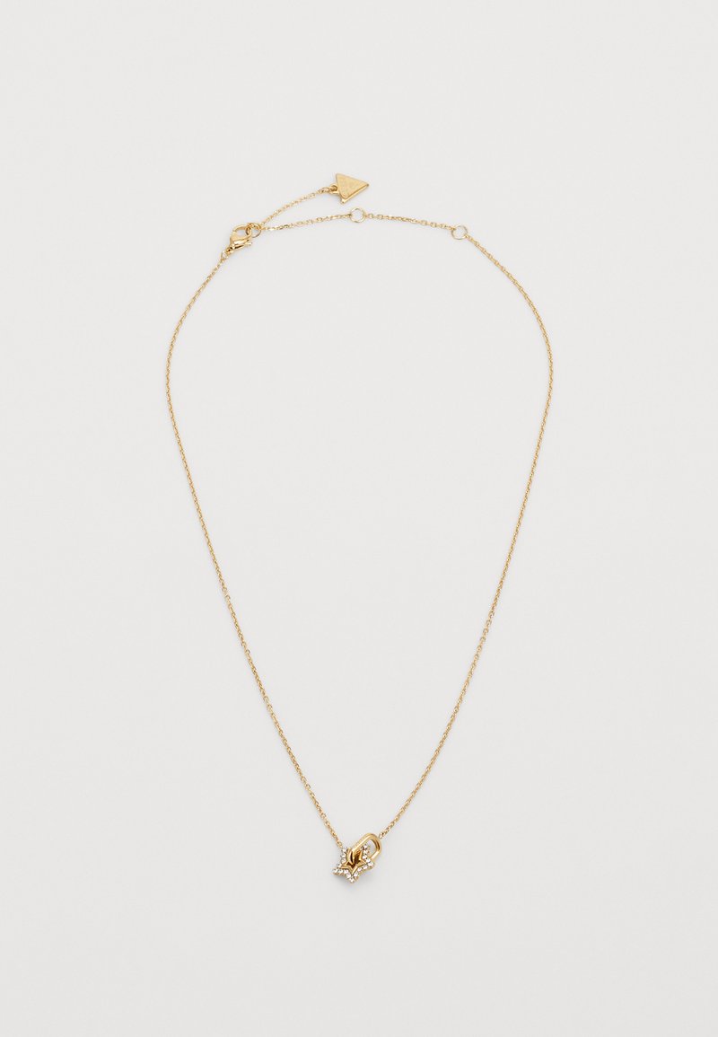 Collier en chaîne dorée avec un petit pendentif en forme d'étoile, orné de petites pierres transparentes, et une fermeture à clapet.
