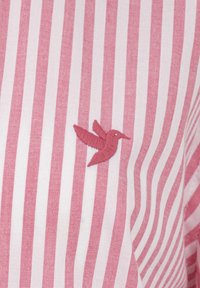 Tessuto a righe di colore rosa chiaro e bianco, con un piccolo colibrì ricamato di un rosa più scuro. Morbida texture, design a vestibilità regolare.