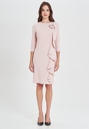 Hellrosanes Kleid mit rundem Ausschnitt, Dreiviertelärmeln und einem Rüschendetail an der Seite. Der Stoff wirkt glatt mit einem floralen Akzent.