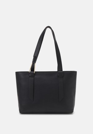 Bolso tote de cuero negro con dos correas largas y detalle de hebilla en tono dorado en una correa, sobre un fondo claro y liso.