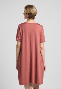 Kurzärmliges, knielanges Kleid aus weichem, staubigem Rosé-Stoff. Mit einer lockeren Passform, subtiler Textur und einem runden Ausschnitt.