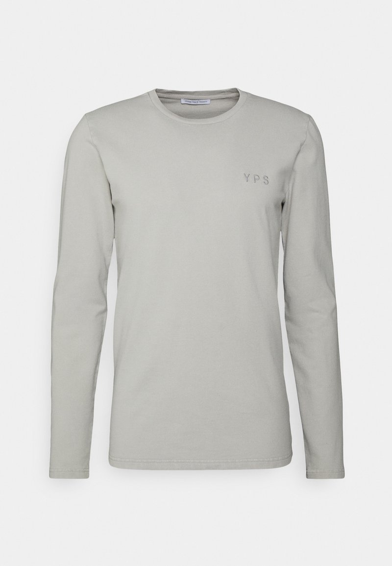 Langärmliges, hellgraues T-Shirt aus weichem Baumwollstoff. Verfügt über einen runden Ausschnitt und ein kleines, gesticktes "YPS"-Logo auf der linken Brust.