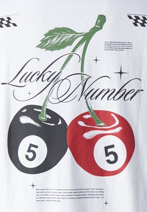 T-shirt blanc avec un graphisme de deux cerises, l'une noire et l'autre rouge, toutes deux portant le chiffre 5. Le texte indique "Numéro Chanceux" en cursive.