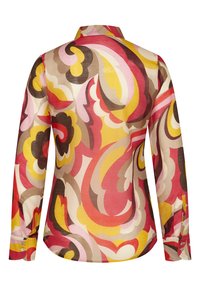 Camisa de manga larga en una tela ligera con un patrón retro de espirales multicolores en rojos, amarillos, rosas y marrones. Presenta un cuello y puños con botones.
