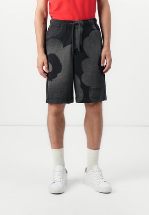 Black shorts with a floral pattern in varying shades of gray, featuring an elastic waistband and side pockets. Paired with white sneakers and socks.