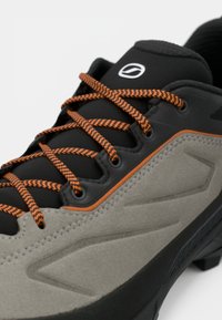 Gray and black hiking shoe with textured suede upper, orange accents, and black laces; features a durable rubber sole and streamlined design.