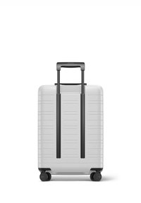 Bagages rigides argentés avec une surface texturée, deux roues noires, et une poignée rétractable centrée à l'arrière, comportant des rainures verticales.