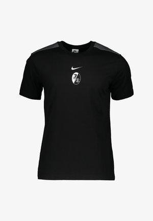 T-shirt Nike nera a maniche corte con pannelli grigio scuro sulle spalle e un piccolo logo bianco della squadra sportiva centrato sotto il swoosh Nike.