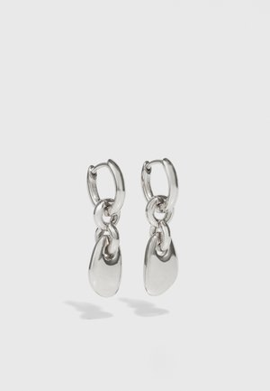 Pendientes de aro de plata con enlaces ovalados alargados, con un acabado pulido y un colgante con textura. Diseño sencillo con bordes suaves.