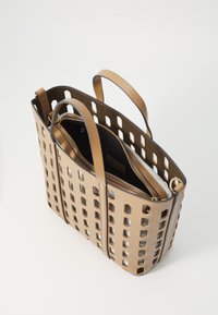 Beige perforatie tote tas met dubbele handvatten en een binnenzak met rits. Kenmerkt zich door een gestructureerde vorm en een gladde textuur.