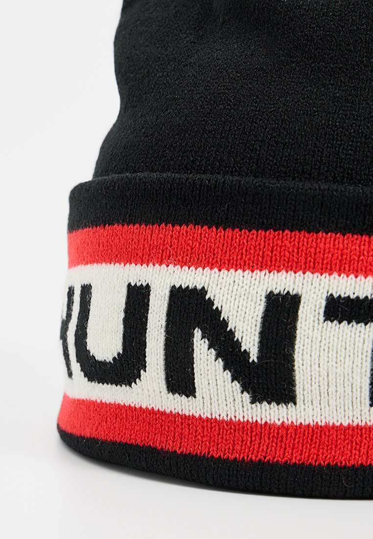 Czarna dzianinowa czapka z dużym paskiem w kolorach czerwonym i białym, z napisem "RUN" dużymi czarnymi literami wzdłuż krawędzi.
