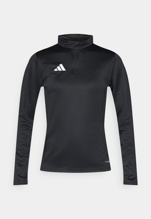 Haut de sport noir à manches longues avec col montant, fermeture éclair quart de zip, et accent de logo blanc sur le côté gauche de la poitrine. Fabriqué en tissu lisse et extensible.