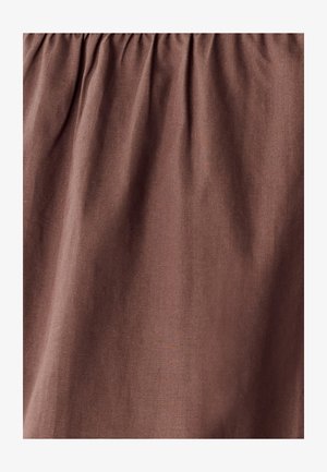 Pruun kangas, millel on sile tekstuur ja pehme langevus. Materjalil on peened variatsioonid, mis loovad pehme ja lõdva väljanägemise.