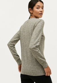 Langærmet grå sweatshirt med et tekstureret mønster, rund halsudskæring og ribbede manchetter, der har en diskret logo-detalje på ryggen.