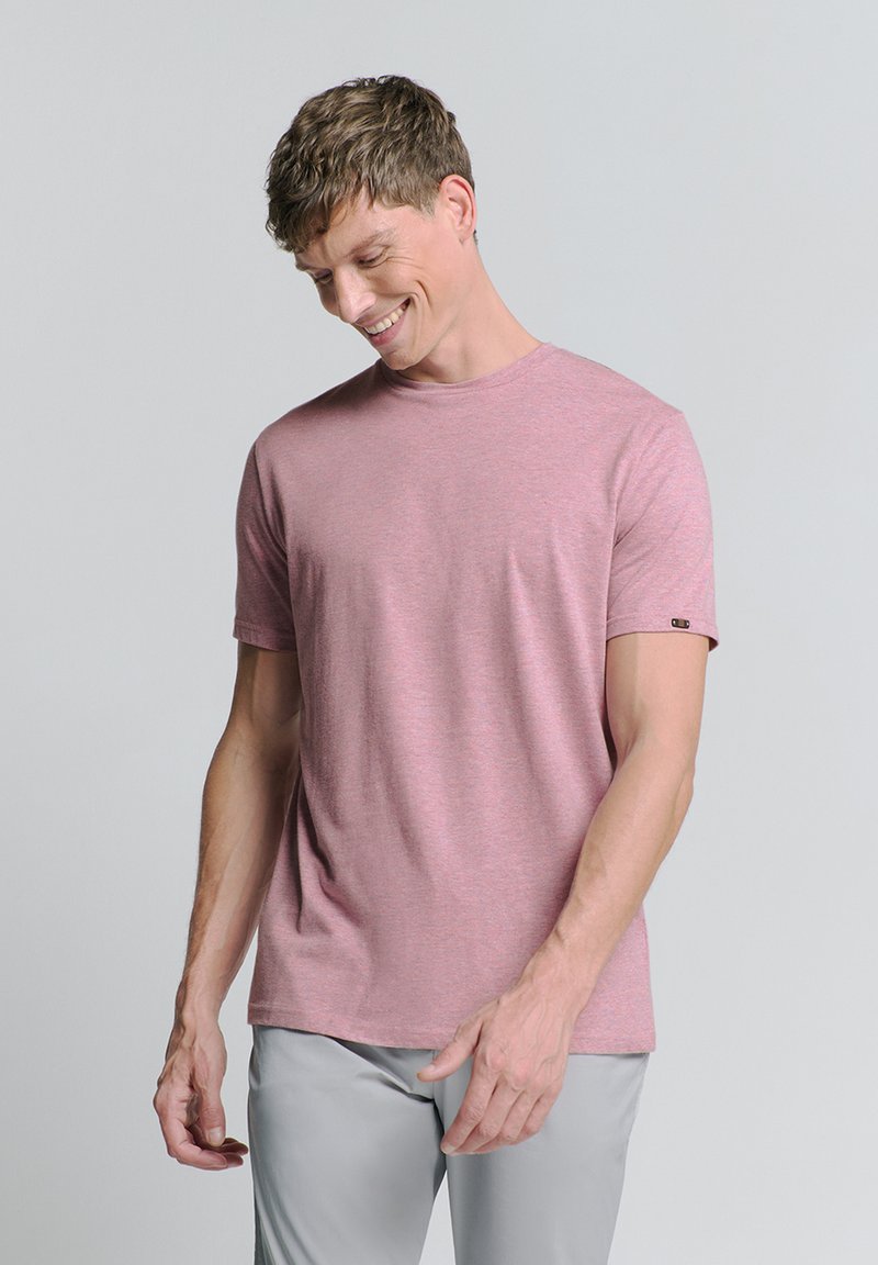 Lichtroze T-shirt met ronde hals, gemaakt van een zachte stof. Korte mouwen, ontspannen pasvorm, met een klein logo-accent op de linkermouw.