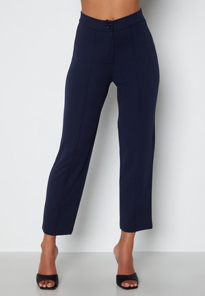 Pantaloni blu navy realizzati in un tessuto liscio ed elasticizzato. Presentano una vita aderente, davanti piatto con bottone e gambe dritte e alla caviglia.