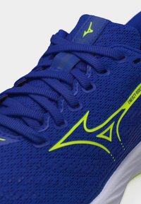 Blue running shoe with neon yellow logo, mesh fabric, laces tied, and "ENERZY RIDER" text on the side above white sole.