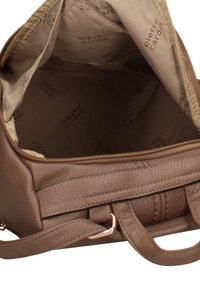 Sac à main en cuir marron avec une surface texturée, des ferrures dorées et une doublure beige ornée du nom de la marque imprimé, l'intérieur montre un compartiment spacieux.