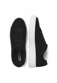 Baskets en suede noir avec une semelle en caoutchouc blanc, présentant des lacets ronds, un design basse et un accent de panneau latéral texturé.